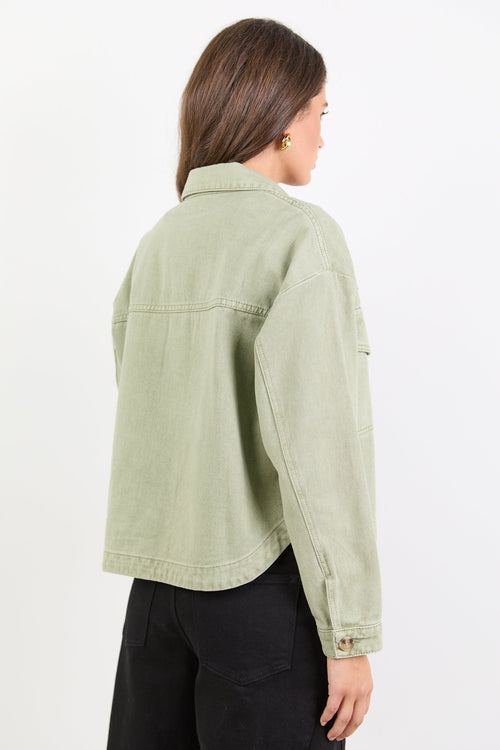 Woman wearing a light green jacket on a white background