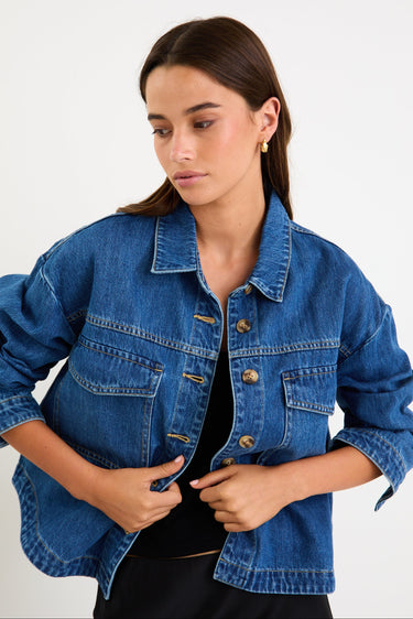 Model wearing a storm-blue denim jacket with patch pockets, button front and a relaxed fit.