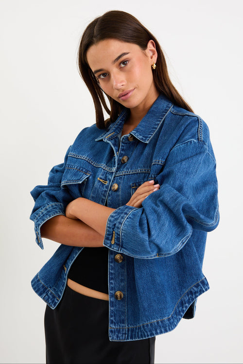 Model wearing a storm-blue denim jacket with patch pockets, button front and a relaxed fit.