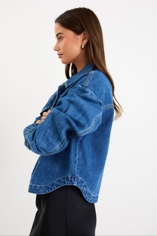 Model wearing a storm-blue denim jacket with patch pockets, button front and a relaxed fit.