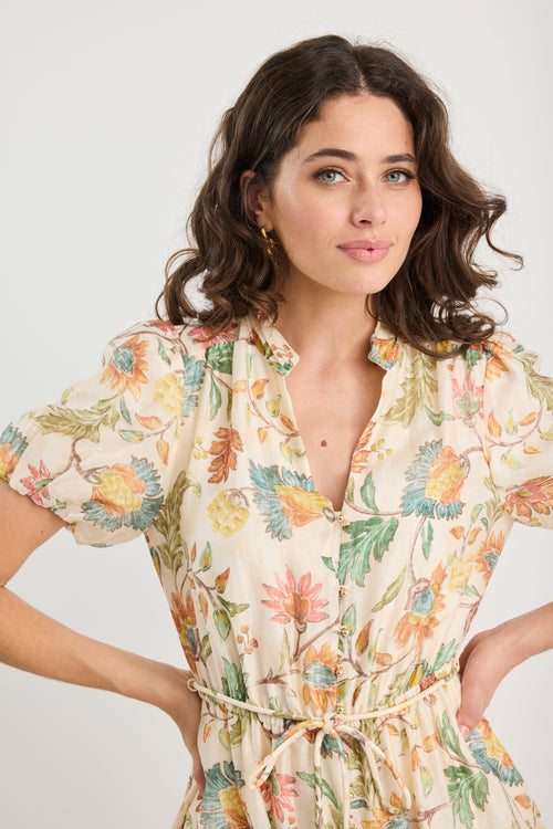 Woman wearing a floral dress against a plain background