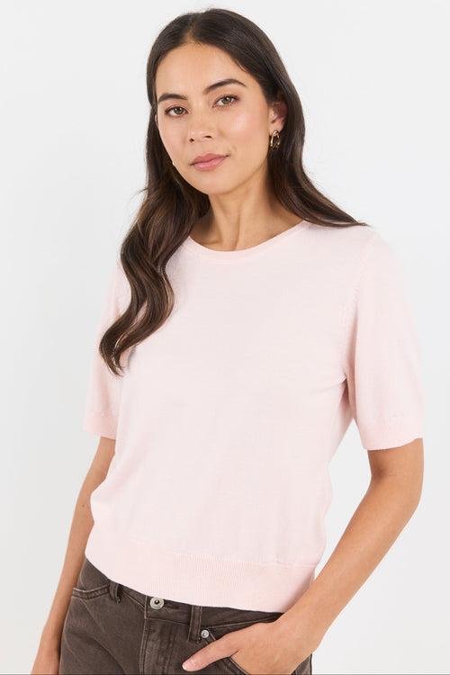 Woman wearing a light pink t-shirt against a white background
