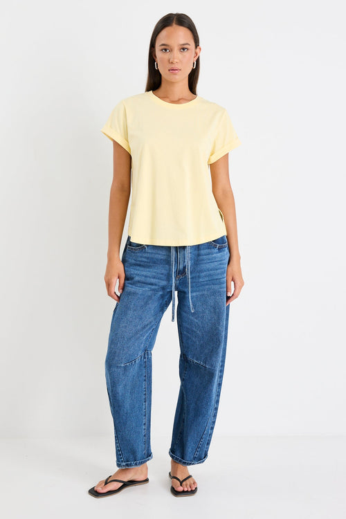 Woman wearing a yellow tee and blue jeans