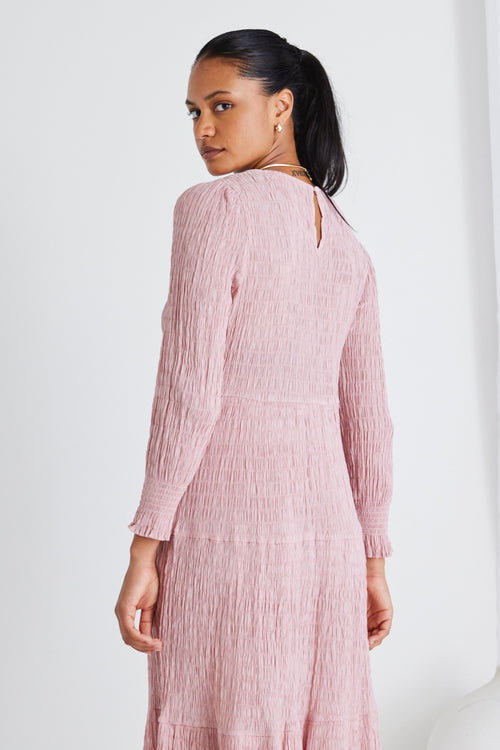 model wears a pink long sleeve dress