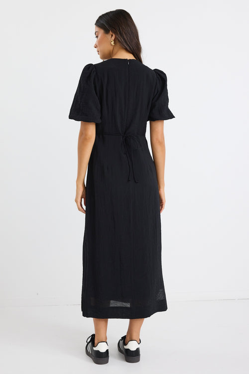 model wears a black puff sleeve midi dress