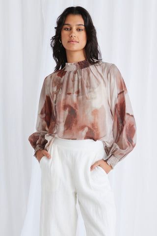 model wears a brown print blouse