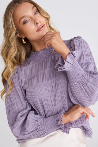 model wears a purple long sleeve top