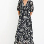 Woman wearing a black and white patterned dress on a white background