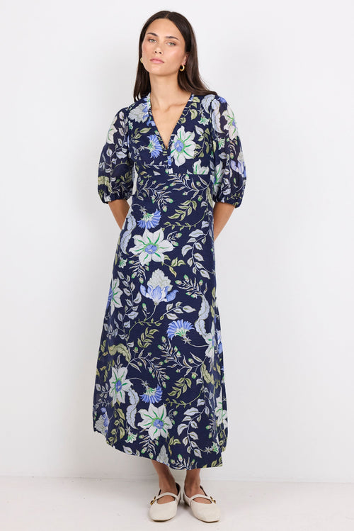 Woman wearing a navy floral dress on a white background