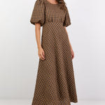 Woman wearing a brown checkered dress on a white background