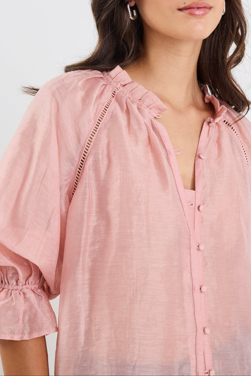 Woman wearing a pink blouse with a plain background
col_pattern