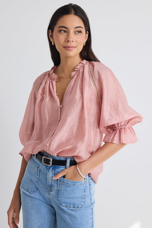 model wears a pink blouse