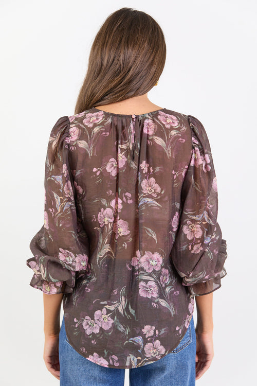 Woman wearing a floral blouse with long sleeves on a white background