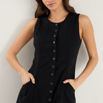 model wears a black button up mini dress with sneakers