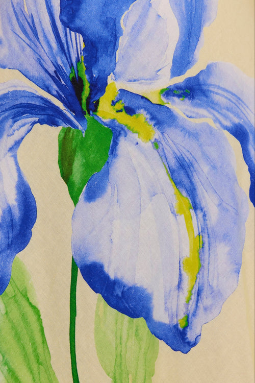 Watercolor painting of a blue iris flower with green leaves on a textured beige background.