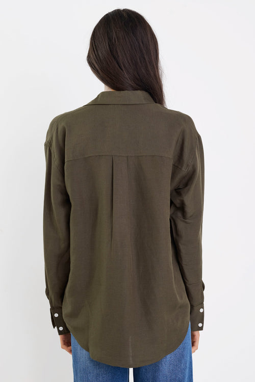 Person wearing an olive green shirt and blue jeans on a white background