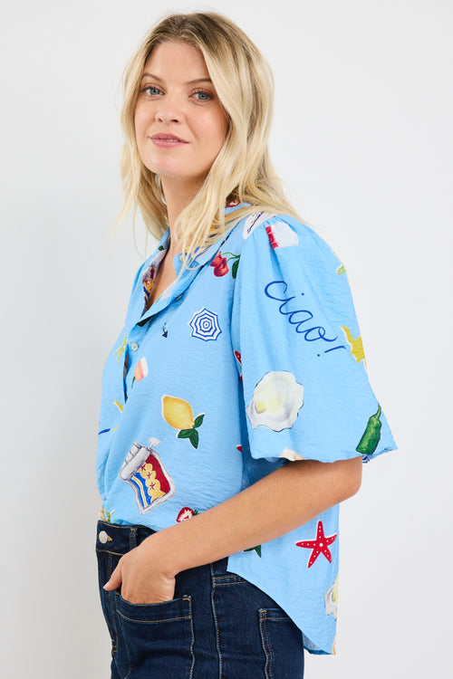 model wears a blue printed tie up puff sleeve shirt with dark blue jeans