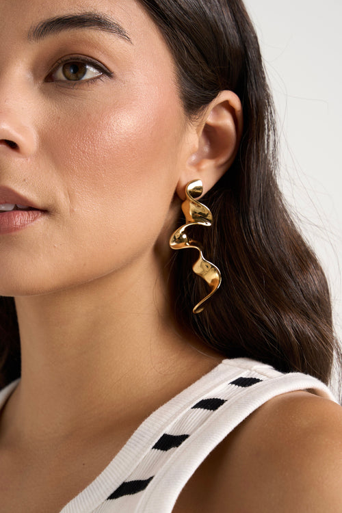 model wears gold earrings