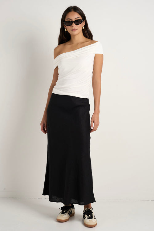 model wears a black linen midi skirt