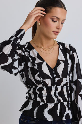 model wears a black and white print top