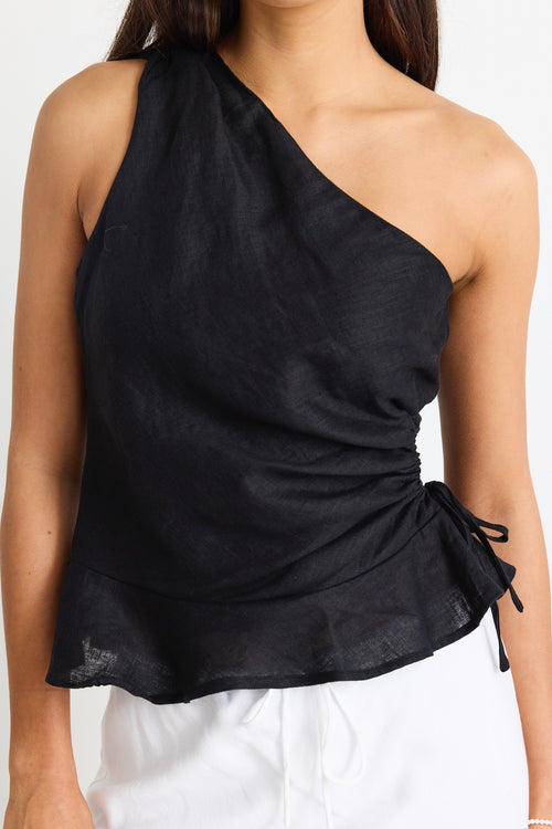 model wears a one shoulder black linen top