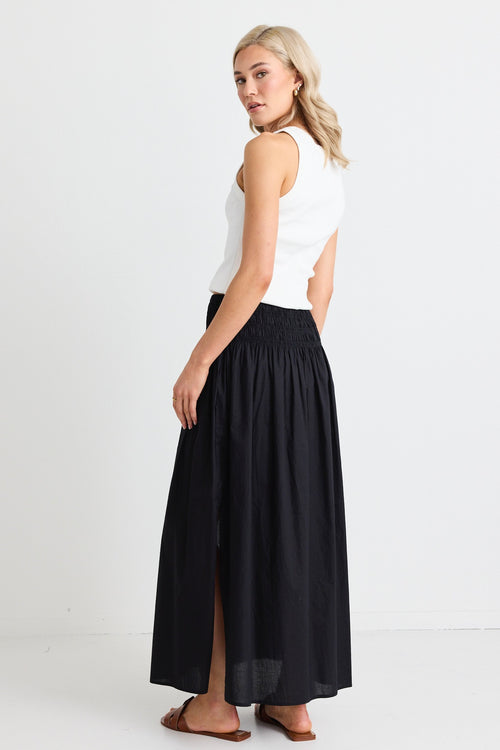 model wears white tank and black cotton maxi skirt