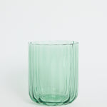 Green glass tumbler on a white background