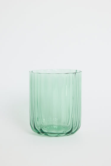 Green glass tumbler on a white background