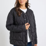 Woman wearing a black quilted jacket on a white background