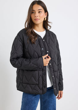 Woman wearing a black quilted jacket on a white background