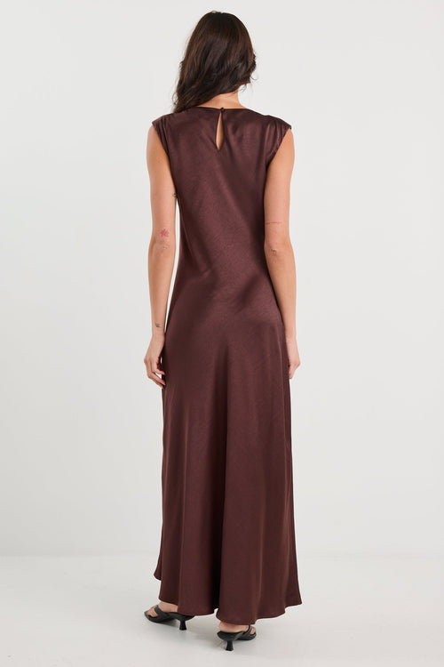 Woman wearing a brown dress from behind on a white background