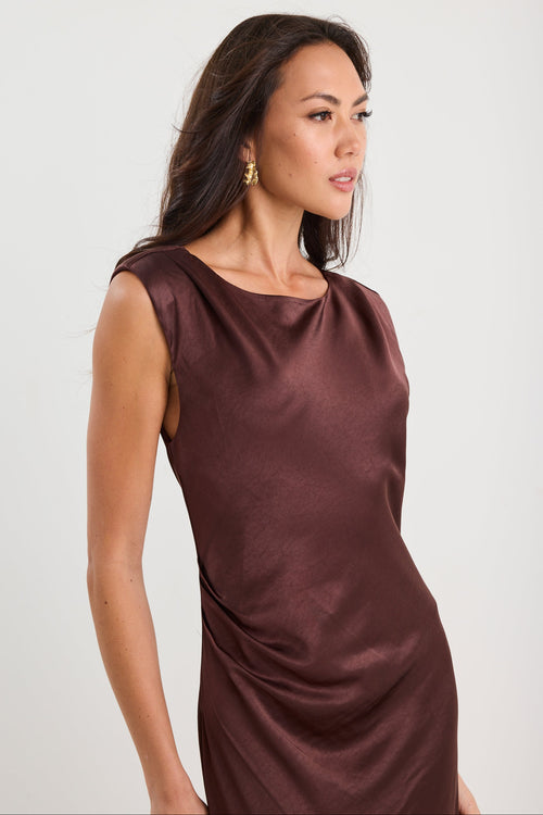 Woman wearing a brown satin dress against a white background