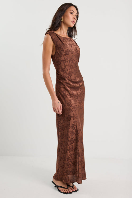 Woman wearing a brown patterned dress on a white background