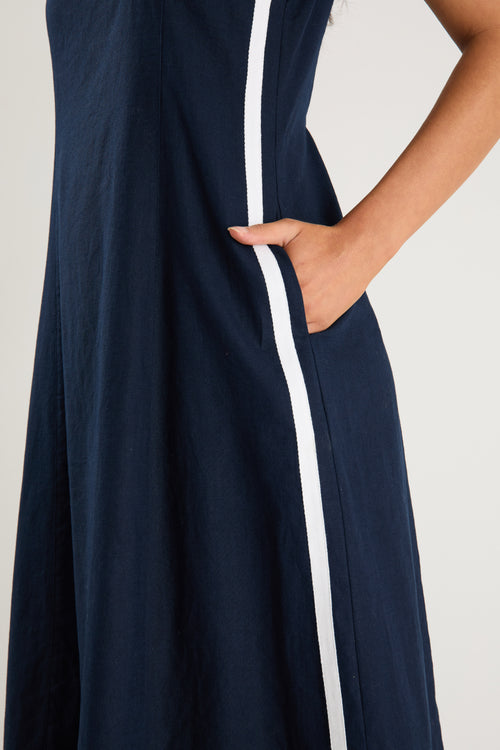the model wears a navy and white stripe maxi dress with sneakers