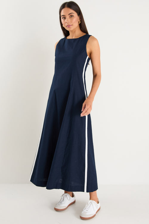 the model wears a navy and white stripe maxi dress with sneakers
