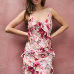 Woman wearing a floral dress against a pink textured background