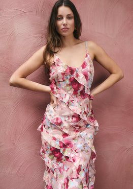 Woman wearing a floral dress against a pink textured background
