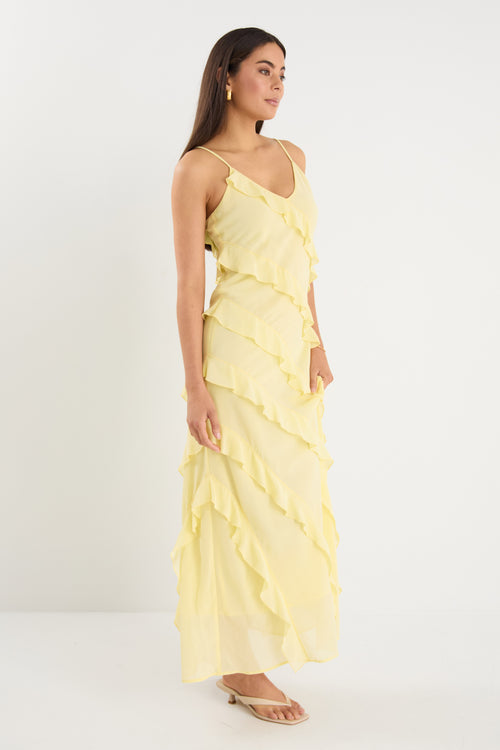 The model wears a yellow ruffle maxi dress