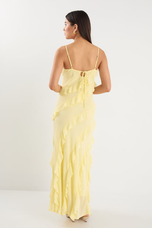 The model wears a yellow ruffle maxi dress