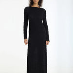 Woman wearing a black long-sleeve dress on a white background
