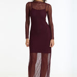 Woman wearing a burgundy dress with sheer sleeves on a white background