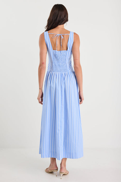 Woman wearing a blue striped dress on a white background