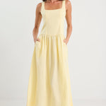 Woman wearing a light yellow dress on a white background