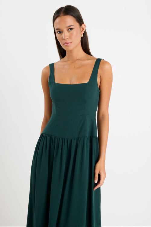 Woman wearing a dark green dress against a white background