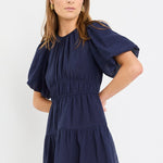 Woman wearing a navy blue dress on a white background