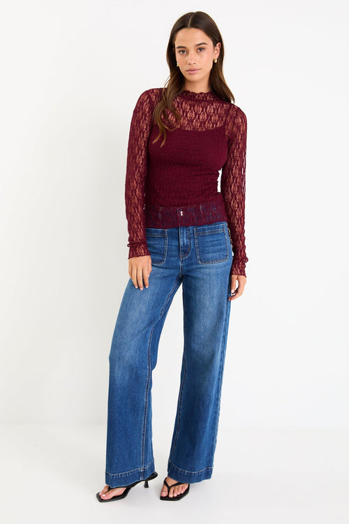 Model wearing a burgundy long sleeve lace top with a matching camisole underneath