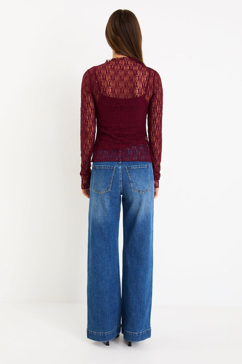 Model wearing a burgundy long sleeve lace top with a matching camisole underneath
