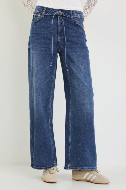 Blue jeans worn by a person on a white background