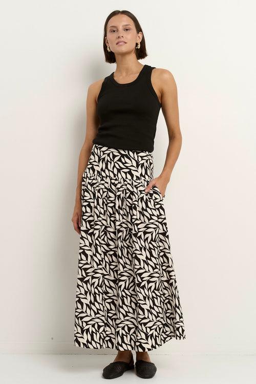 our model wears a black and white floral print maxi skirt with a black tank