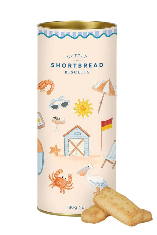 A cylindrical tin of Butter Shortbread Biscuits with a cream-colored label decorated with beach-themed illustrations, with two golden-brown biscuits placed in front on a white background.